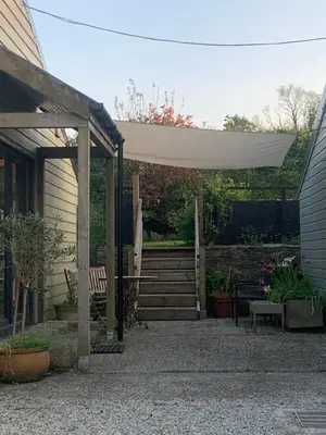 a patio with a white canopy and a bench at Field View in Liskeard
