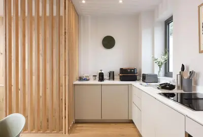 a kitchen with white counters and a wooden partition at Lefransa in Carbis Bay, St Ives in Carbis Bay