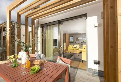 a dining room with a table and a living room at Lefransa in Carbis Bay, St Ives in Carbis Bay