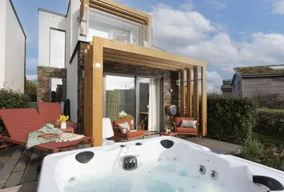 a bath tub sitting on a deck next to a house at Lefransa in Carbis Bay, St Ives in Carbis Bay
