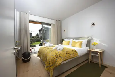 a bedroom with a large bed with a yellow blanket at Lefransa in Carbis Bay, St Ives in Carbis Bay