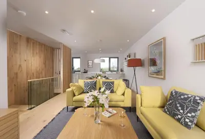 a living room with two yellow couches and a table at Lefransa in Carbis Bay, St Ives in Carbis Bay