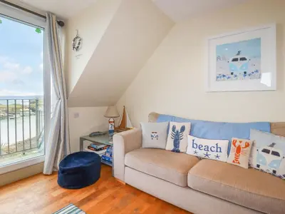 a living room with a couch and a window at Driftwood in Newquay