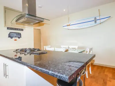 a kitchen with a counter top and a surfboard on the wall at Driftwood in Newquay