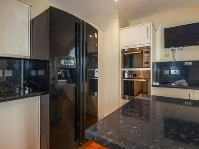 a kitchen with a refrigerator and a counter top at Driftwood in Newquay