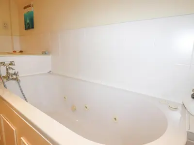 a white bath tub in a bathroom at Driftwood in Newquay