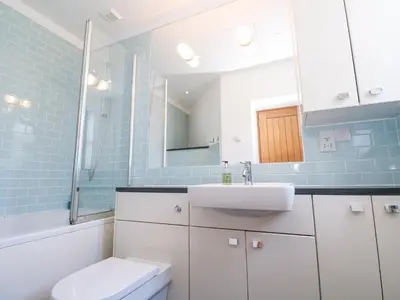 a bathroom with a sink and a toilet and a mirror at The Observatory Tower in Falmouth