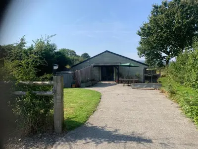 a house with a fence next to a driveway at Field End in Liskeard