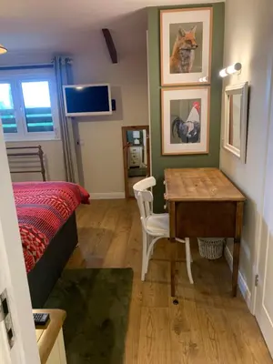 a bedroom with a desk and a bed and a table at Field End in Liskeard