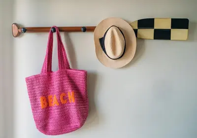 a pink bag and a hat hanging on a wall at Bijou Beachfront Gem, Rock in Padstow