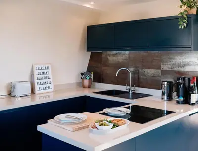 a kitchen with a sink and a counter with dishes on it at Bijou Beachfront Gem, Rock in Padstow