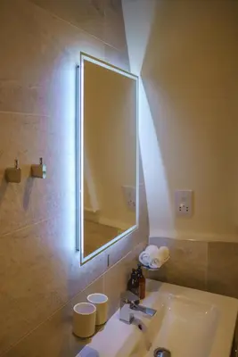 a bathroom with a sink and a large mirror at Bijou Beachfront Gem, Rock in Padstow