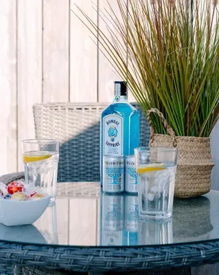 a bottle of water and two glasses on a table at Bijou Beachfront Gem, Rock in Padstow