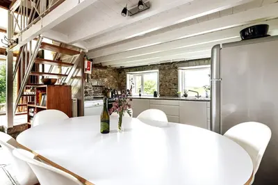 a kitchen with a white table and white chairs at Abel's Cottage gorgeous character barn Crackington in Crackington Haven