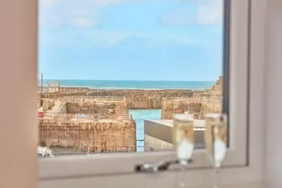 a window with a view of the ocean at Harbour View apartment in Portreath in Portreath