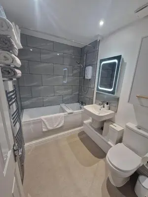 a bathroom with a toilet and a tub and a sink at Harbour View apartment in Portreath in Portreath