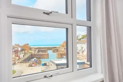 a window with a view of the ocean at Harbour View apartment in Portreath in Portreath