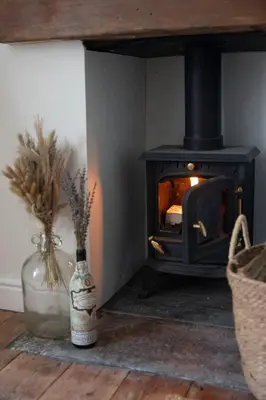 a fireplace with a wood stove in a room at Stylish cottage, log burner - Tregavone Cottage in Falmouth