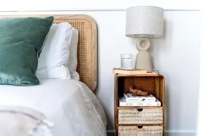 a bed with a green pillow and a lamp on a side table at Harbour sea views in town centre - 3 Headland View in Falmouth