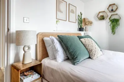 a bed with pillows and a table with a lamp at Harbour sea views in town centre - 3 Headland View in Falmouth