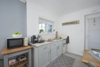 a kitchen with white cabinets and a microwave at Olive Cottage, Carbis Bay - Parking Nearby, Free WiFi, Coffee Machine - Couples Retreat in Carbis Bay