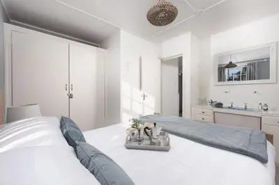 a white bedroom with a large bed and a sink at Olive Cottage, Carbis Bay - Parking Nearby, Free WiFi, Coffee Machine - Couples Retreat in Carbis Bay