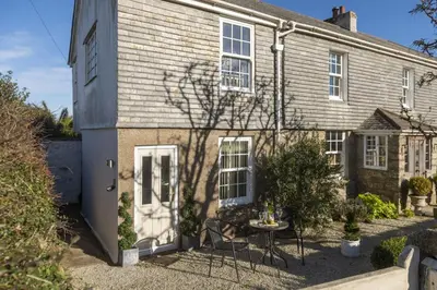 a house with a table and chairs in front of it at Olive Cottage, Carbis Bay - Parking Nearby, Free WiFi, Coffee Machine - Couples Retreat in Carbis Bay
