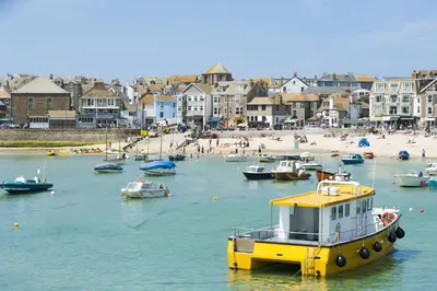a yellow boat in the water next to a beach at Olive Cottage, Carbis Bay - Parking Nearby, Free WiFi, Coffee Machine - Couples Retreat in Carbis Bay