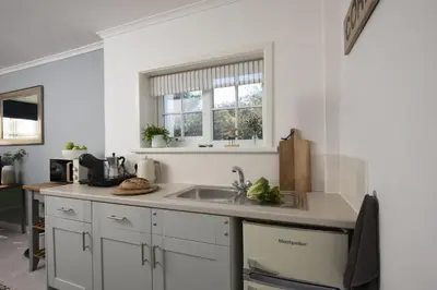 a white kitchen with a sink and a window at Olive Cottage, Carbis Bay - Parking Nearby, Free WiFi, Coffee Machine - Couples Retreat in Carbis Bay