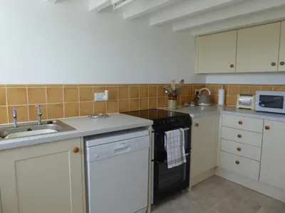 a kitchen with a sink and a stove top oven at Lower Tresmorn Cottage in Crackington Haven