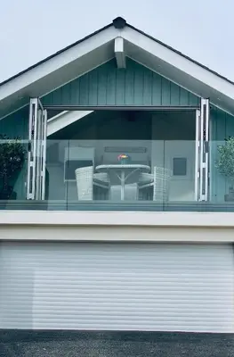 a garage door with a window on a house at Kittiwake Retreat, a luxury escape by the sea! in Gorran Haven