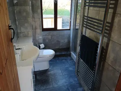 a bathroom with a sink and a toilet and a window at The Dairy Barn in Camelford