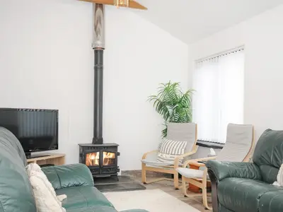 a living room with two couches and a fireplace at The Dairy Barn in Camelford