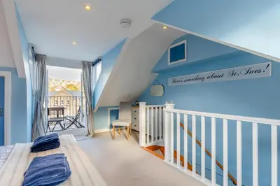 a bedroom with blue walls and a staircase with a bed at 3 Bed in St. Ives oc-c30654 in St Ives