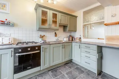 a kitchen with white cabinets and a black oven at 3 Bed in St. Ives oc-s30653 in St Ives