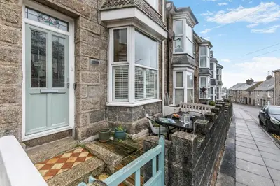 a brick house with a white door and a patio at 3 Bed in St. Ives oc-s30653 in St Ives