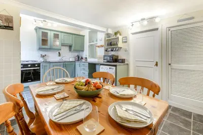 a kitchen with a wooden table with a bowl of fruit on it at 3 Bed in St. Ives oc-s30653 in St Ives