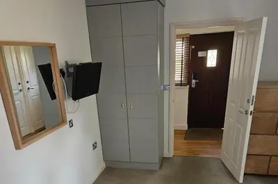 a room with a mirror and a cabinet with a television at 2br-sleeps4-pool-freeparking-trenythonestate in Par