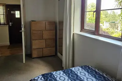 a bedroom with a bed and a window and a dresser at 2br-sleeps4-pool-freeparking-trenythonestate in Par