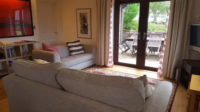 a living room with two couches and a sliding glass door at 2br-sleeps4-pool-freeparking-trenythonestate in Par