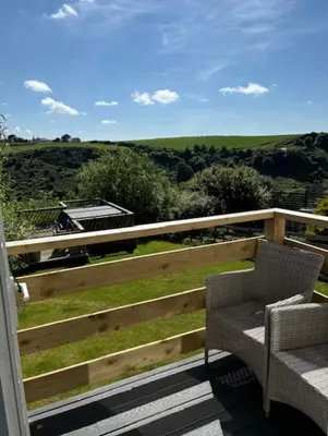 a balcony with a bench and a view of a field at Valley View in Port Isaac