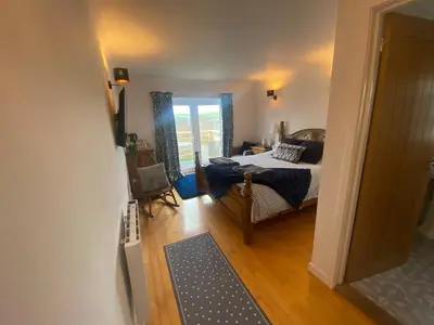 a bedroom with a bed and a room with a window at Valley View in Port Isaac