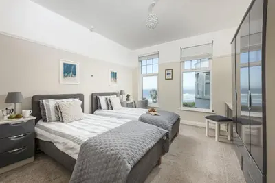 a bedroom with two beds and a tv at Beachside Fistral, Newquay in Newquay