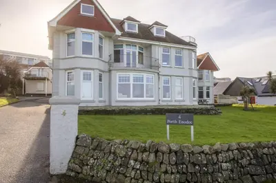 a large white house with a sign in front of it at Beachside Fistral, Newquay in Newquay