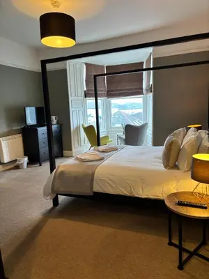 a bedroom with a large bed with a large window at The Mariners in Falmouth