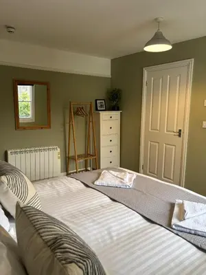 a bedroom with a large bed and a dresser at The Mariners in Falmouth