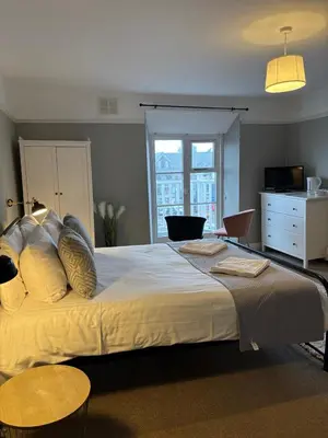 a bedroom with a large bed and a window at The Mariners in Falmouth