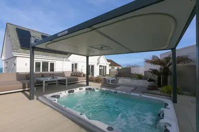 a patio with a hot tub on a deck at Solstice in Carbis Bay