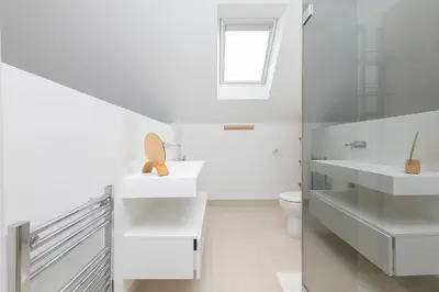 a white bathroom with two sinks and a toilet at Solstice in Carbis Bay