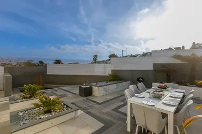 a patio with a white table and chairs on a patio at Solstice in Carbis Bay